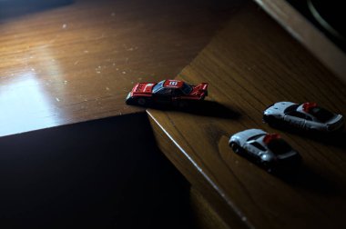 Cenova, İtalya - 20th NOVEMBER 2025 - Nissan Skyline Turbo Super Silueti 'nin kırmızı ve siyah yarış kıyafetleri içindeki Takara Tomi kopyaları Nissan Skyline GT-R R34 ve Japon polis üniformalarındaki Nissan Fairlady 350Z al