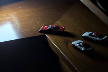 Cenova, İtalya - 20th NOVEMBER 2025 - Nissan Skyline Turbo Super Silueti 'nin kırmızı ve siyah yarış kıyafetleri içindeki Takara Tomi kopyaları Nissan Skyline GT-R R34 ve Japon polis üniformalarındaki Nissan Fairlady 350Z al