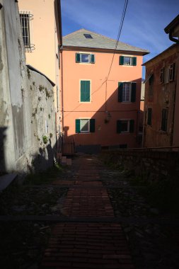 Merdiven, evlerin arasında beton bir korkulukla çevrili. Kısmen güneş gören bir uçurumun kenarında.