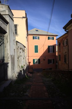 Merdiven, evlerin arasında beton bir korkulukla çevrili. Kısmen güneş gören bir uçurumun kenarında.