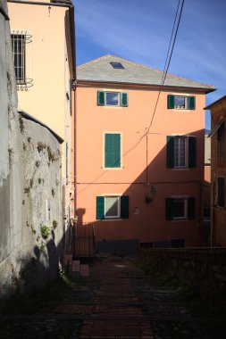 Merdiven, evlerin arasında beton bir korkulukla çevrili. Kısmen güneş gören bir uçurumun kenarında.