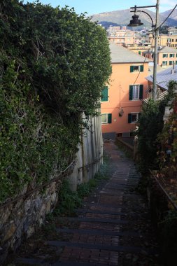 Merdiven, evlerin arasında beton bir korkulukla çevrili. Kısmen güneş gören bir uçurumun kenarında.