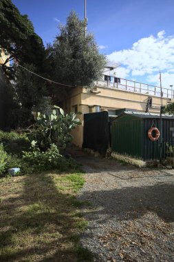 Kumsalda, çitlerle çevrili bir kumsalda, güneşli bir günde kümelenmiş teknelerle dolu bir binada.