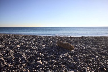 Drywood gün batımında çakıl taşlı bir plajda yatıyor. Sahilin hemen yanında.