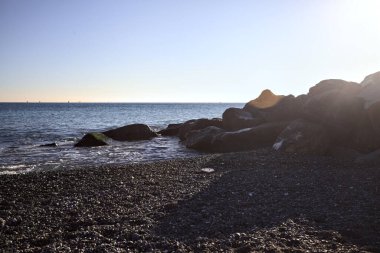 Gölgede kayalar ve gün batımında kayaların üzerinde filtrelenen güneş ışığı grubu.