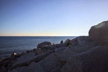 Gölgede kayalar ve gün batımında kayaların üzerinde filtrelenen güneş ışığı grubu.
