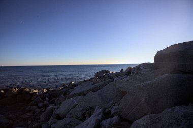 Gölgede kayalar ve gün batımında kayaların üzerinde filtrelenen güneş ışığı grubu.