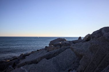 Gölgede kayalar ve gün batımında kayaların üzerinde filtrelenen güneş ışığı grubu.