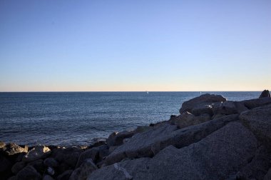 Gölgede kayalar ve gün batımında kayaların üzerinde filtrelenen güneş ışığı grubu.