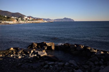 Deniz kenarındaki bina ve bulvar. Denizin üzerindeki küçük bir uçurumdan görülebiliyor. Kışın gün batımında sahneyi çerçeveliyorlar.