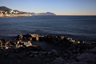 Deniz kenarındaki bina ve bulvar. Denizin üzerindeki küçük bir uçurumdan görülebiliyor. Kışın gün batımında sahneyi çerçeveliyorlar.