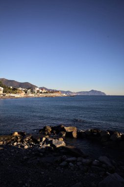Deniz kenarındaki bina ve bulvar. Denizin üzerindeki küçük bir uçurumdan görülebiliyor. Kışın gün batımında sahneyi çerçeveliyorlar.