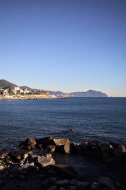 Deniz kenarındaki bina ve bulvar. Denizin üzerindeki küçük bir uçurumdan görülebiliyor. Kışın gün batımında sahneyi çerçeveliyorlar.