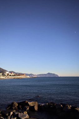 Deniz kenarındaki bina ve bulvar. Denizin üzerindeki küçük bir uçurumdan görülebiliyor. Kışın gün batımında sahneyi çerçeveliyorlar.