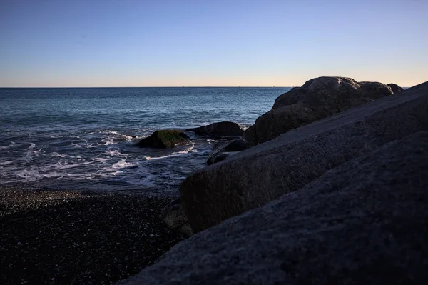 Gölgede kayalar ve gün batımında kayaların üzerinde filtrelenen güneş ışığı grubu.