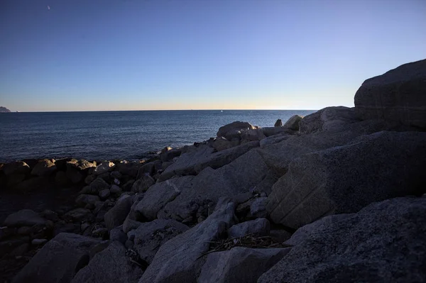 Gölgede kayalar ve gün batımında kayaların üzerinde filtrelenen güneş ışığı grubu.