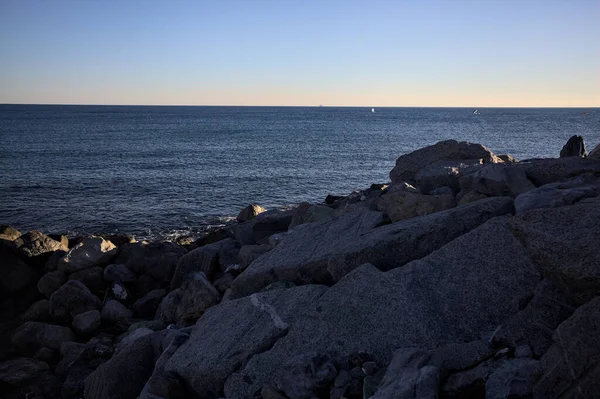 Gölgede kayalar ve gün batımında kayaların üzerinde filtrelenen güneş ışığı grubu.