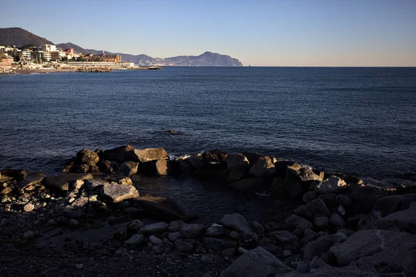 Deniz kenarındaki bina ve bulvar. Denizin üzerindeki küçük bir uçurumdan görülebiliyor. Kışın gün batımında sahneyi çerçeveliyorlar.