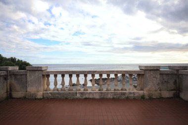 Bir gezinti güvertesinde balkonda tırabzanlar, üzerinde bulutlu bir gökyüzü, bir kış günü, denizi çerçeve