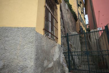 Bulutlu bir günde yeşil bir kapı tarafından engellenen tarihi binalar arasındaki dar merdivenler