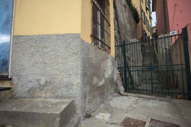 Bulutlu bir günde yeşil bir kapı tarafından engellenen tarihi binalar arasındaki dar merdivenler