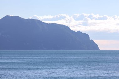 Güneşli bir günde, deniz kenarında, bulutların ardında uçurum.