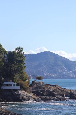 Evin etrafı kayalıklarla çevrili, kayalıklarla denize doğru uzanan kayalıklar ve güneşli bir günde uzak bir dağ sırtı ile çevrili.