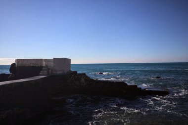 Kayalarla çevrili dar bir koy ve güneşli bir günde üzerinde bir köprü olan panoramik bir nokta.