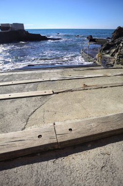 Kayalarla çevrili dar bir koy ve güneşli bir günde üzerinde bir köprü olan panoramik bir nokta.