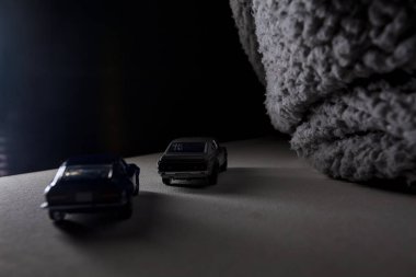 Mantova, İtalya - 3RD JANUARY 2025 Takara Tomy kopyaları gri Nissan Skyline 2000 GT-R ve mavi Nissan Fairlady Z beyaz bir panoda, gri bir kumaş parçasının yanında, uçurumun kenarındaki bir dağ yolunda yarış yapıyormuş gibi yapıyor.