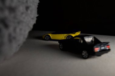 Mantova, İtalya - 3RD JANUARY 2025 - 1990 model Acura NSX ve 1984 model Toyota MR2 'nin kopyaları, gri bir kumaş parçasının yanında, uçurumun kenarındaki bir dağ yolunda yarış yapıyormuş gibi yapıyor.