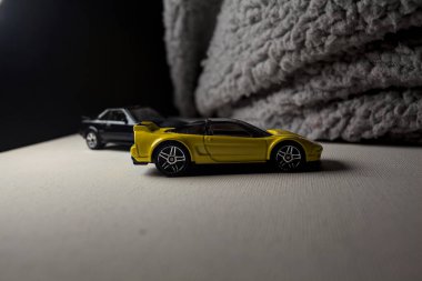 Mantova, İtalya - 3RD JANUARY 2025 - 1990 model Acura NSX ve 1984 model Toyota MR2 'nin kopyaları, gri bir kumaş parçasının yanında, uçurumun kenarındaki bir dağ yolunda yarış yapıyormuş gibi yapıyor.