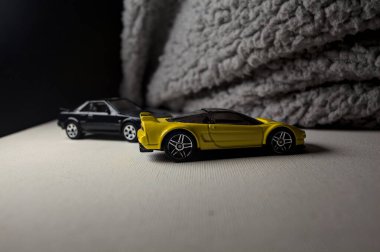 Mantova, İtalya - 3RD JANUARY 2025 - 1990 model Acura NSX ve 1984 model Toyota MR2 'nin kopyaları, gri bir kumaş parçasının yanında, uçurumun kenarındaki bir dağ yolunda yarış yapıyormuş gibi yapıyor.