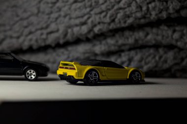 Mantova, İtalya - 3RD JANUARY 2025 - 1990 model Acura NSX ve 1984 model Toyota MR2 'nin kopyaları, gri bir kumaş parçasının yanında, uçurumun kenarındaki bir dağ yolunda yarış yapıyormuş gibi yapıyor.