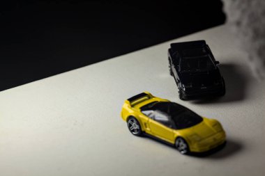 Mantova, İtalya - 3RD JANUARY 2025 - 1990 model Acura NSX ve 1984 model Toyota MR2 'nin kopyaları, gri bir kumaş parçasının yanında, uçurumun kenarındaki bir dağ yolunda yarış yapıyormuş gibi yapıyor.