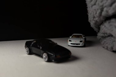 Mantova, İtalya - 3RD JANUARY 2025 - 1989 Mazda Savanna RX-7 'nin Ateşli Tekerlekleri ve Kibrit kutusu kopyaları ve beyaz bir tahtanın üzerinde beyaz bir kumaş parçasının yanında, uçurumun kenarındaki bir dağ yolunda yarış yapıyormuş gibi yapan Mitsubishi 3000 GT