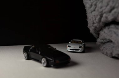 Mantova, İtalya - 3RD JANUARY 2025 - 1989 Mazda Savanna RX-7 'nin Ateşli Tekerlekleri ve Kibrit kutusu kopyaları ve beyaz bir tahtanın üzerinde beyaz bir kumaş parçasının yanında, uçurumun kenarındaki bir dağ yolunda yarış yapıyormuş gibi yapan Mitsubishi 3000 GT