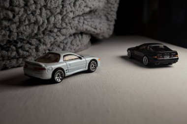 Mantova, İtalya - 3RD JANUARY 2025 - 1989 Mazda Savanna RX-7 'nin Ateşli Tekerlekleri ve Kibrit kutusu kopyaları ve beyaz bir tahtanın üzerinde beyaz bir kumaş parçasının yanında, uçurumun kenarındaki bir dağ yolunda yarış yapıyormuş gibi yapan Mitsubishi 3000 GT