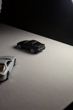 Mantova, İtalya - 3RD JANUARY 2025 - 1989 Mazda Savanna RX-7 'nin Ateşli Tekerlekleri ve Kibrit kutusu kopyaları ve beyaz bir tahtanın üzerinde beyaz bir kumaş parçasının yanında, uçurumun kenarındaki bir dağ yolunda yarış yapıyormuş gibi yapan Mitsubishi 3000 GT