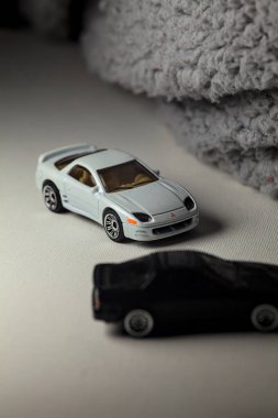 Mantova, İtalya - 3RD JANUARY 2025 - 1989 Mazda Savanna RX-7 'nin Ateşli Tekerlekleri ve Kibrit kutusu kopyaları ve beyaz bir tahtanın üzerinde beyaz bir kumaş parçasının yanında, uçurumun kenarındaki bir dağ yolunda yarış yapıyormuş gibi yapan Mitsubishi 3000 GT