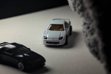 Mantova, İtalya - 3RD JANUARY 2025 - 1989 Mazda Savanna RX-7 'nin Ateşli Tekerlekleri ve Kibrit kutusu kopyaları ve beyaz bir tahtanın üzerinde beyaz bir kumaş parçasının yanında, uçurumun kenarındaki bir dağ yolunda yarış yapıyormuş gibi yapan Mitsubishi 3000 GT