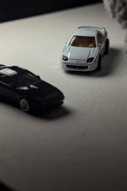 Mantova, İtalya - 3RD JANUARY 2025 - 1989 Mazda Savanna RX-7 'nin Ateşli Tekerlekleri ve Kibrit kutusu kopyaları ve beyaz bir tahtanın üzerinde beyaz bir kumaş parçasının yanında, uçurumun kenarındaki bir dağ yolunda yarış yapıyormuş gibi yapan Mitsubishi 3000 GT