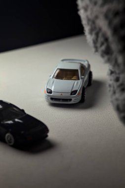 Mantova, İtalya - 3RD JANUARY 2025 - 1989 Mazda Savanna RX-7 'nin Ateşli Tekerlekleri ve Kibrit kutusu kopyaları ve beyaz bir tahtanın üzerinde beyaz bir kumaş parçasının yanında, uçurumun kenarındaki bir dağ yolunda yarış yapıyormuş gibi yapan Mitsubishi 3000 GT