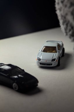 Mantova, İtalya - 3RD JANUARY 2025 - 1989 Mazda Savanna RX-7 'nin Ateşli Tekerlekleri ve Kibrit kutusu kopyaları ve beyaz bir tahtanın üzerinde beyaz bir kumaş parçasının yanında, uçurumun kenarındaki bir dağ yolunda yarış yapıyormuş gibi yapan Mitsubishi 3000 GT