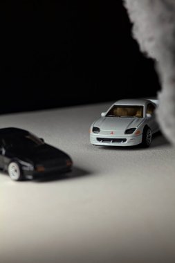 Mantova, İtalya - 3RD JANUARY 2025 - 1989 Mazda Savanna RX-7 'nin Ateşli Tekerlekleri ve Kibrit kutusu kopyaları ve beyaz bir tahtanın üzerinde beyaz bir kumaş parçasının yanında, uçurumun kenarındaki bir dağ yolunda yarış yapıyormuş gibi yapan Mitsubishi 3000 GT