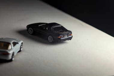 Mantova, İtalya - 3RD JANUARY 2025 - 1989 Mazda Savanna RX-7 'nin Ateşli Tekerlekleri ve Kibrit kutusu kopyaları ve beyaz bir tahtanın üzerinde beyaz bir kumaş parçasının yanında, uçurumun kenarındaki bir dağ yolunda yarış yapıyormuş gibi yapan Mitsubishi 3000 GT