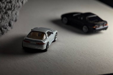 Mantova, İtalya - 3RD JANUARY 2025 - 1989 Mazda Savanna RX-7 'nin Ateşli Tekerlekleri ve Kibrit kutusu kopyaları ve beyaz bir tahtanın üzerinde beyaz bir kumaş parçasının yanında, uçurumun kenarındaki bir dağ yolunda yarış yapıyormuş gibi yapan Mitsubishi 3000 GT