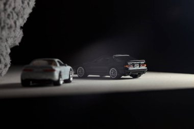 Mantova, İtalya - 3RD JANUARY 2025 - 1989 Mazda Savanna RX-7 'nin Ateşli Tekerlekleri ve Kibrit kutusu kopyaları ve beyaz bir tahtanın üzerinde beyaz bir kumaş parçasının yanında, uçurumun kenarındaki bir dağ yolunda yarış yapıyormuş gibi yapan Mitsubishi 3000 GT