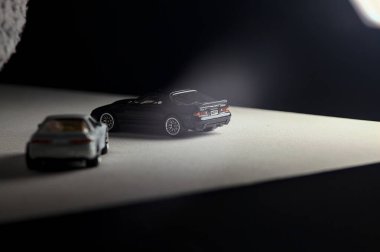 Mantova, İtalya - 3RD JANUARY 2025 - 1989 Mazda Savanna RX-7 'nin Ateşli Tekerlekleri ve Kibrit kutusu kopyaları ve beyaz bir tahtanın üzerinde beyaz bir kumaş parçasının yanında, uçurumun kenarındaki bir dağ yolunda yarış yapıyormuş gibi yapan Mitsubishi 3000 GT