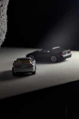 Mantova, İtalya - 3RD JANUARY 2025 - 1989 Mazda Savanna RX-7 'nin Ateşli Tekerlekleri ve Kibrit kutusu kopyaları ve beyaz bir tahtanın üzerinde beyaz bir kumaş parçasının yanında, uçurumun kenarındaki bir dağ yolunda yarış yapıyormuş gibi yapan Mitsubishi 3000 GT